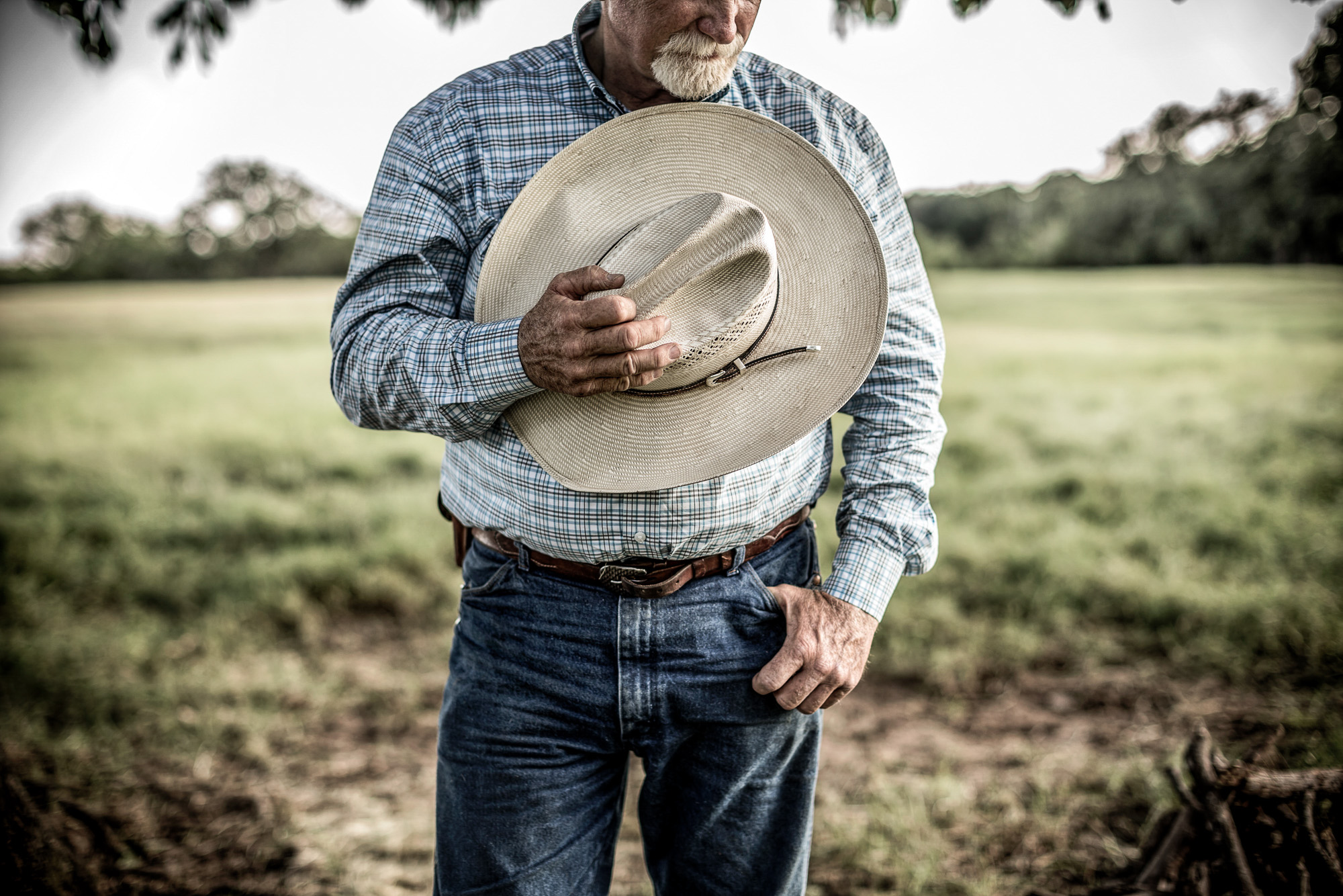 farmer rancher cowboy with cowboy hat over heart looking down