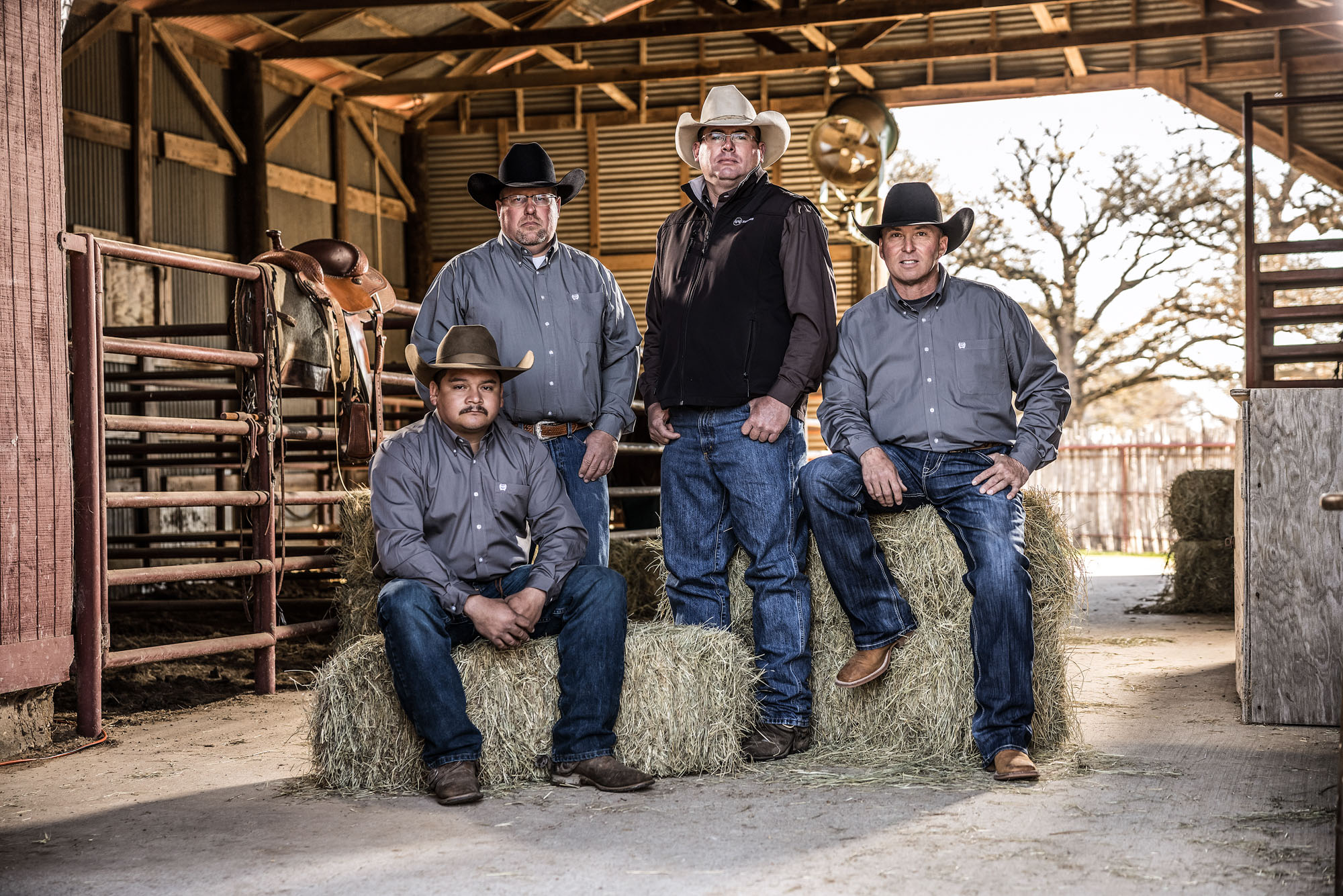 portrait of group of cowboys in barn ranch texas 