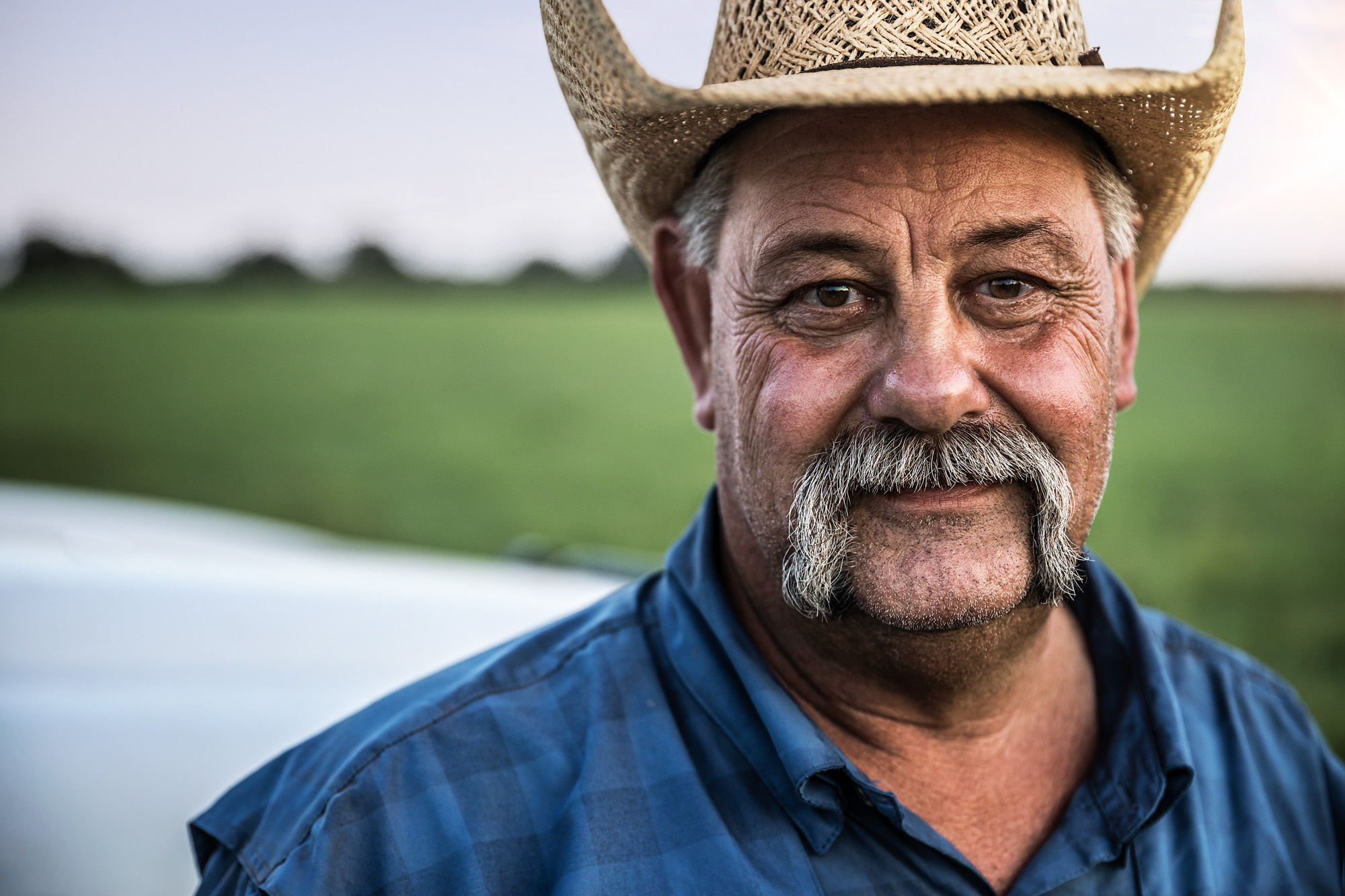 ranch worker portrait at sunset sunrise beauty light close up of face portrait with cowboy hat and mustache