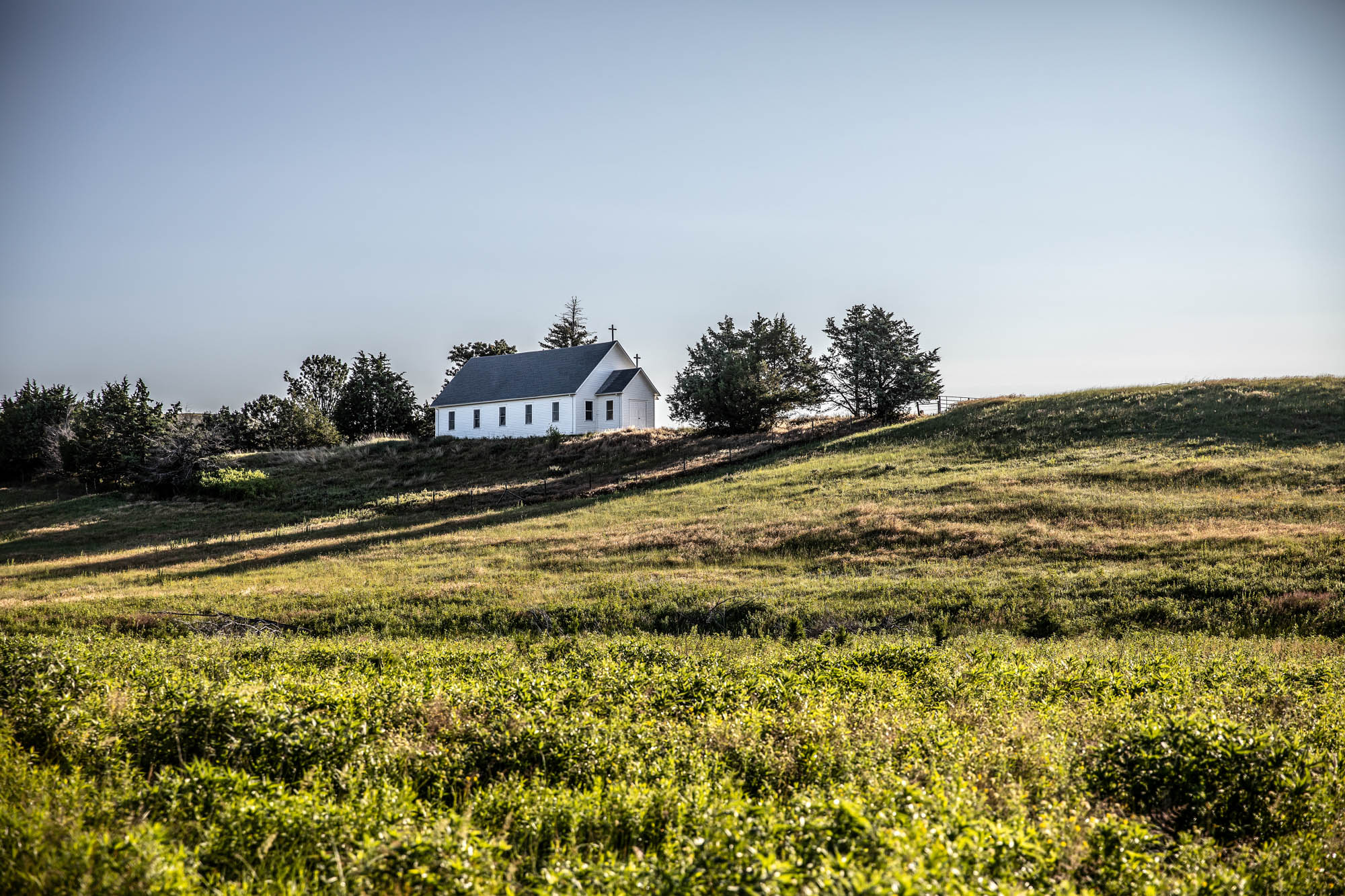 landscape of church in green field up on hill in nebraska