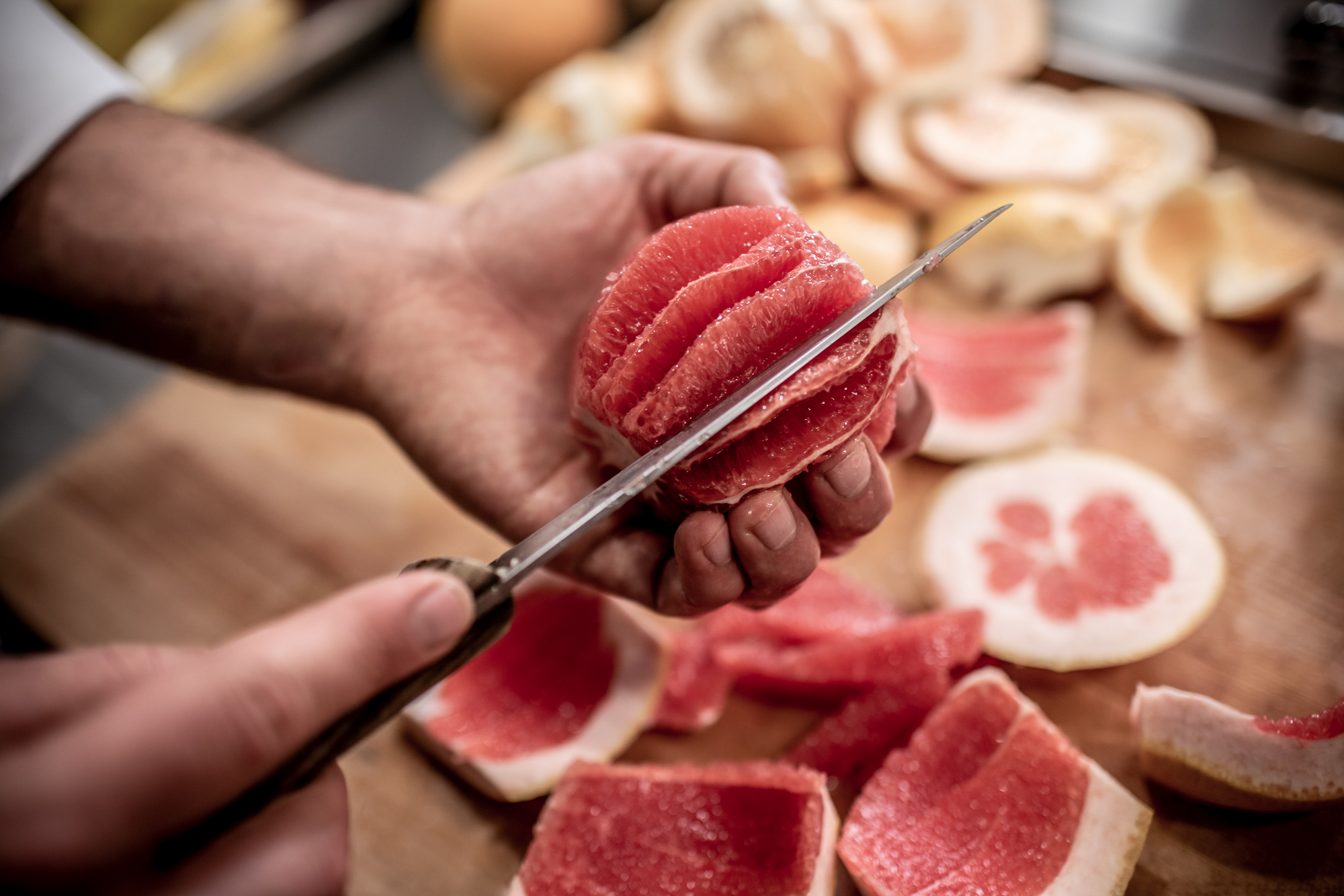 chef cutting up grapefruit