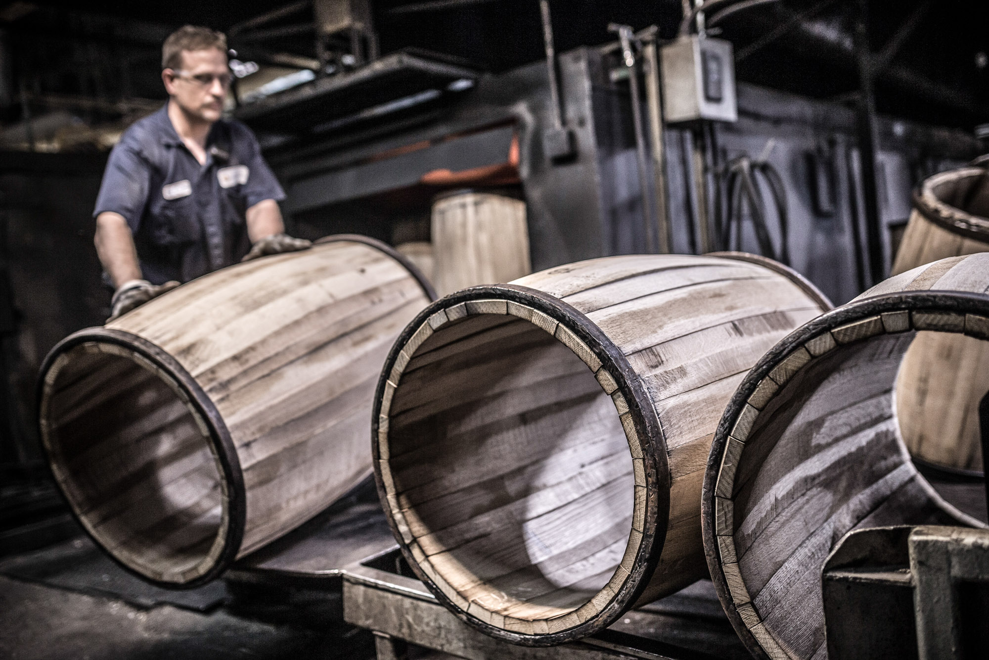 man loading whiskey barrels at independent stave company manufacturing plant in kentucky