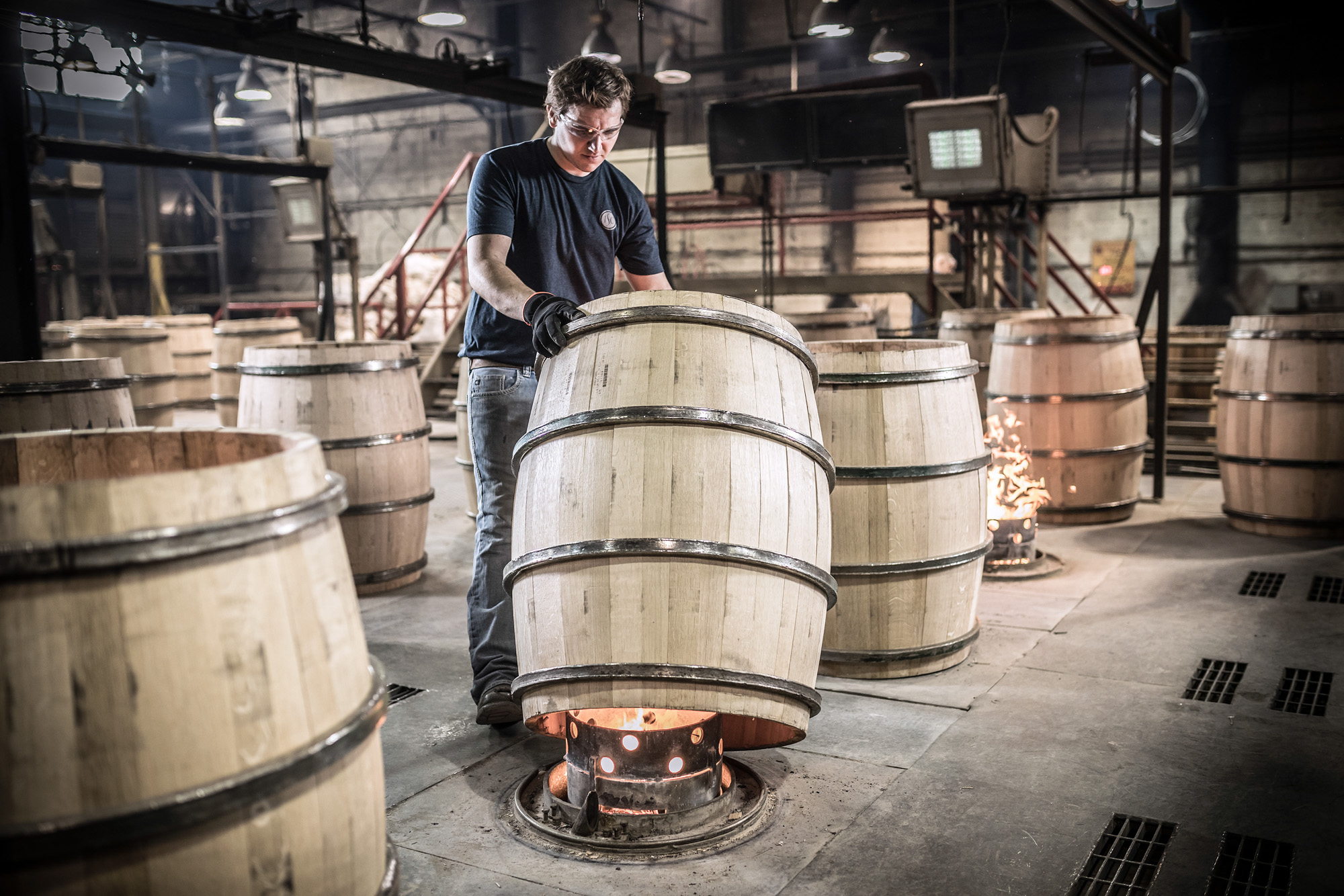 man toasting white oak wine barrel at independent stave company plant in missouri