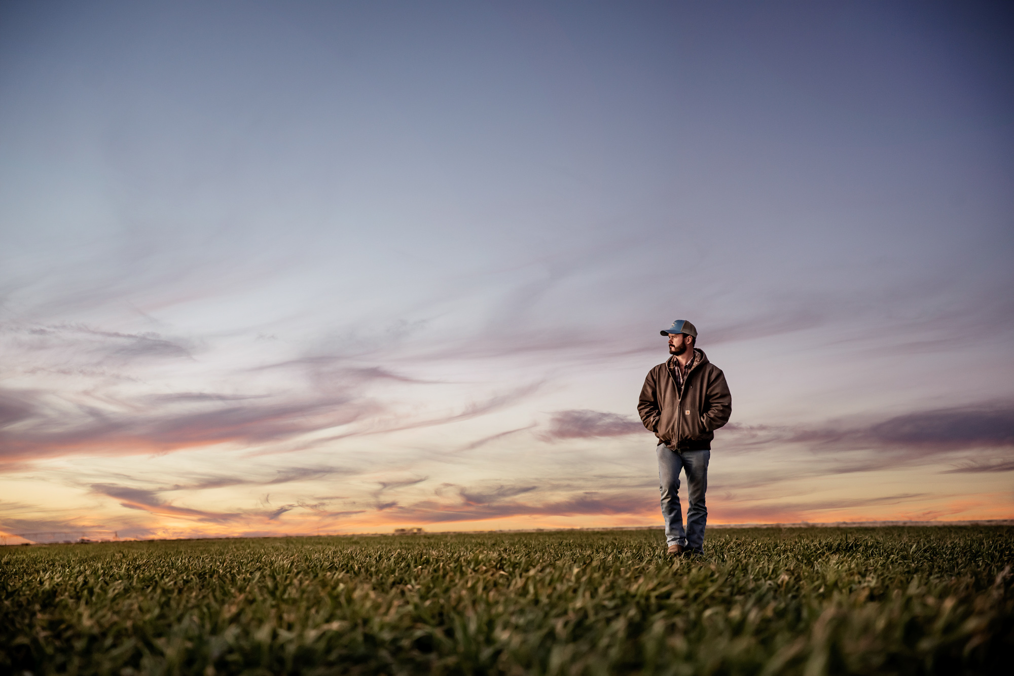 portrait of farmer rancher walking on farm ranch at sunset sunrise