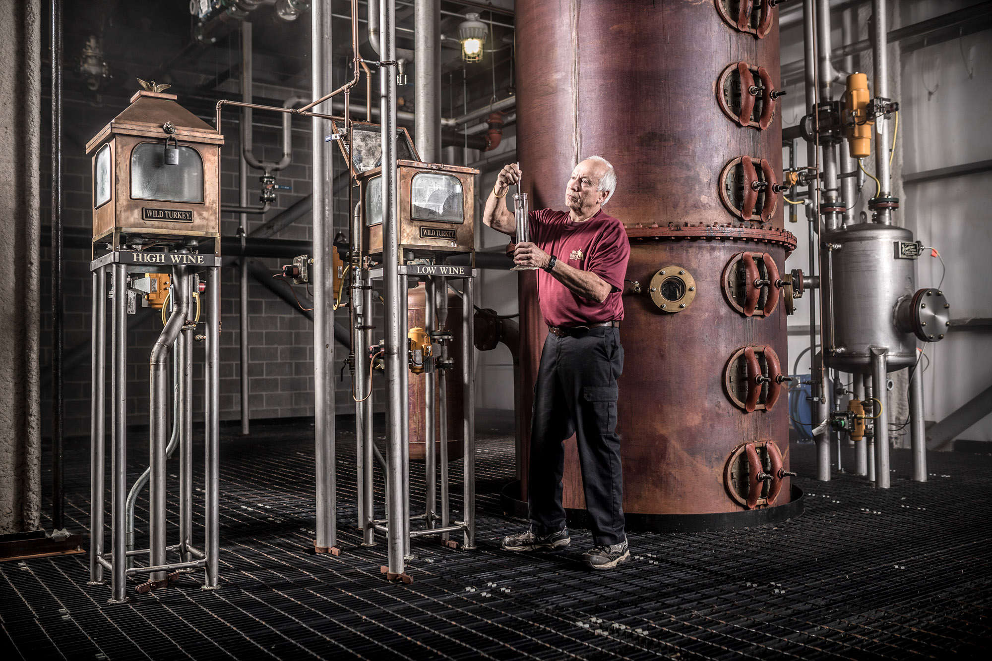 man testing alcohol still at wild turkey russell reserve whiskey bourbon facility plant in kentucky