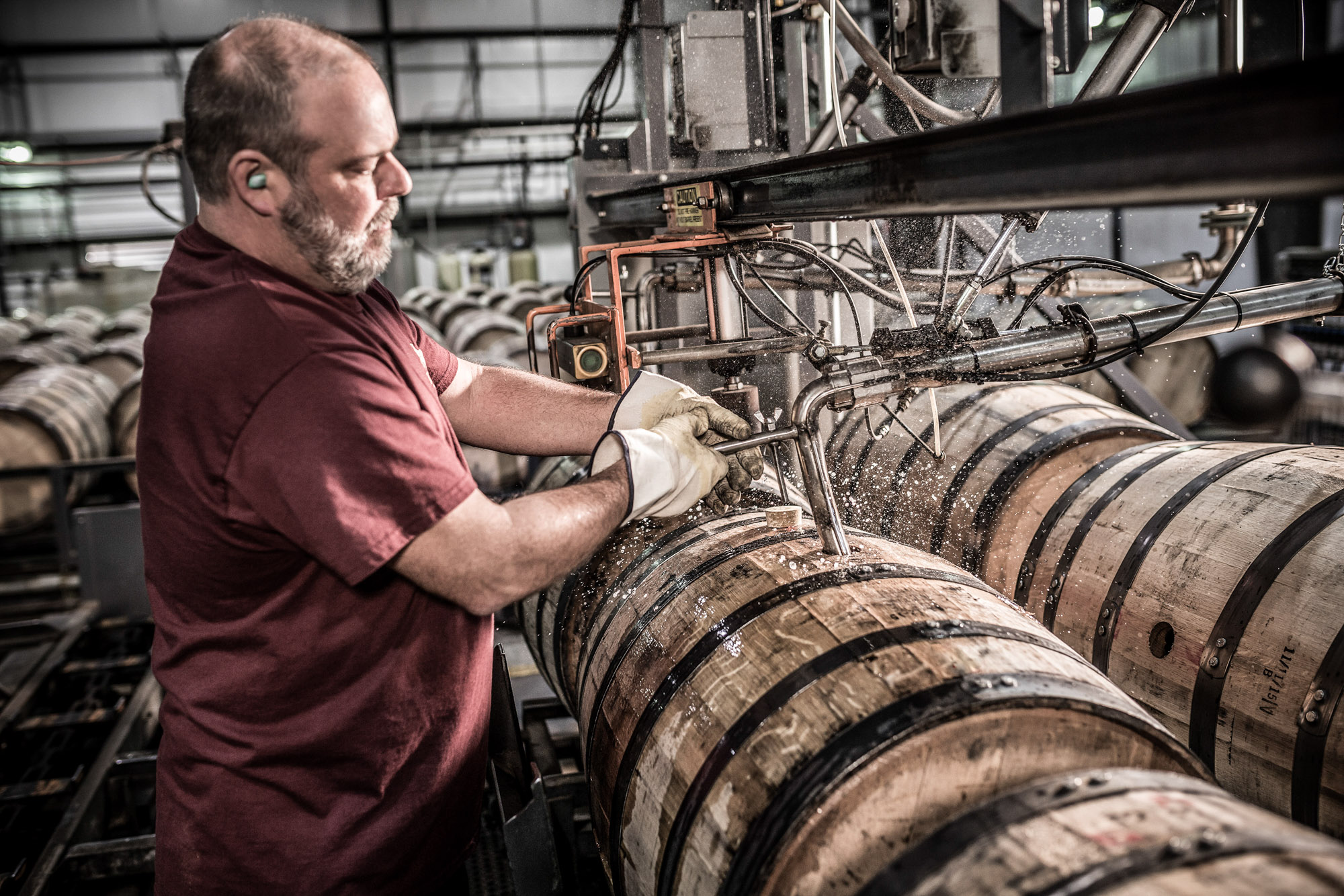 man filling whiskey barrel at wild turkey russell reserve whiskey bourbon plant in kentucky