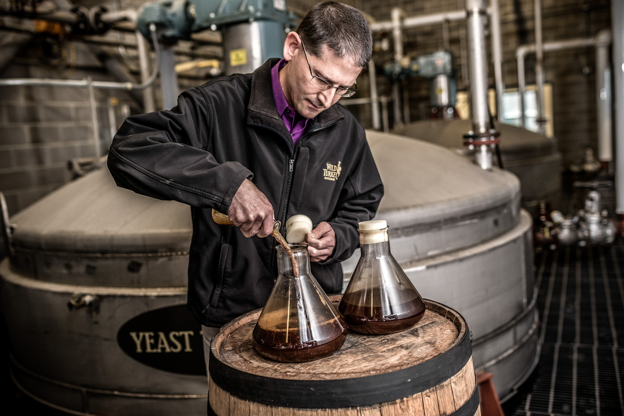 man testing whiskey bourbon mash yeast at wild turkey russells reserve plant in kentucky